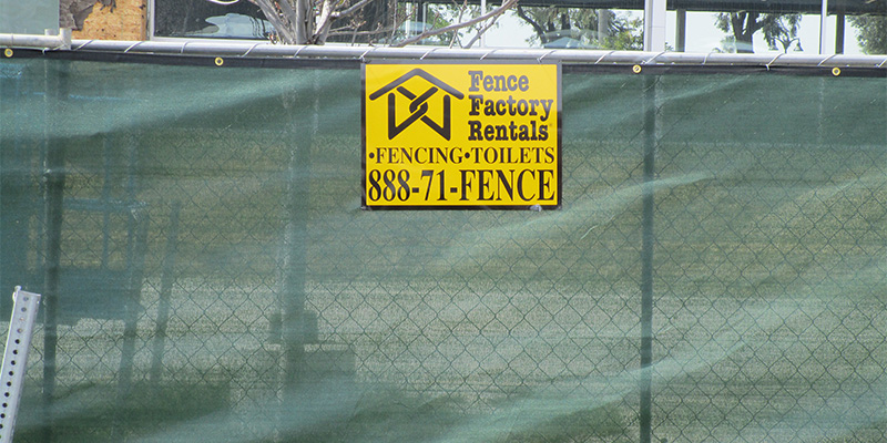 Business Temporary Fences near Visalia, CA, with green privacy screen.